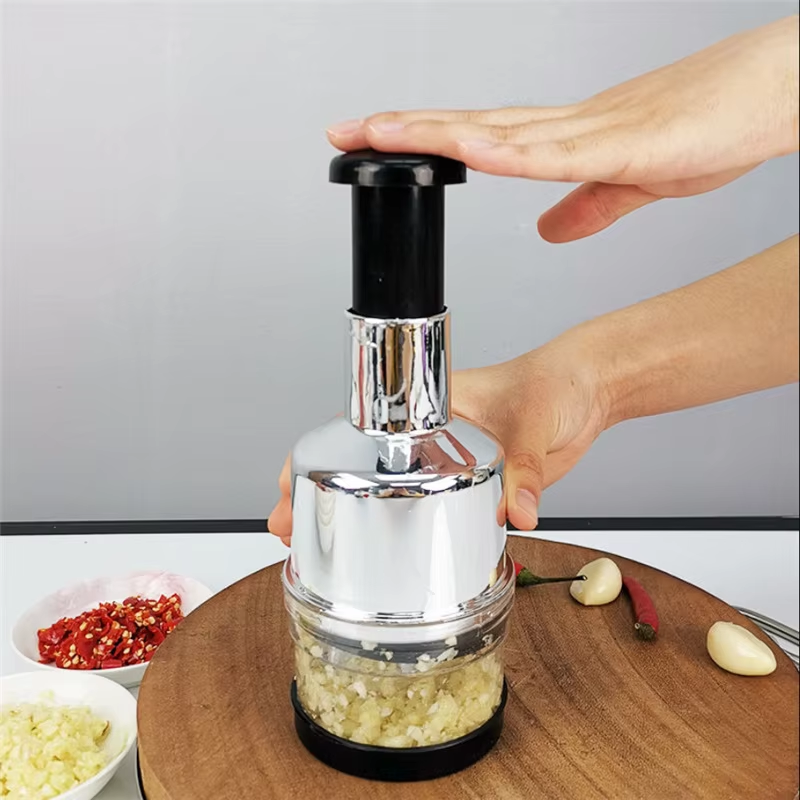 Hand using a garlic press on a wooden cutting board with ingredients in the background.