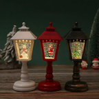 Three decorative Christmas lanterns on a wooden surface with a dark green background.