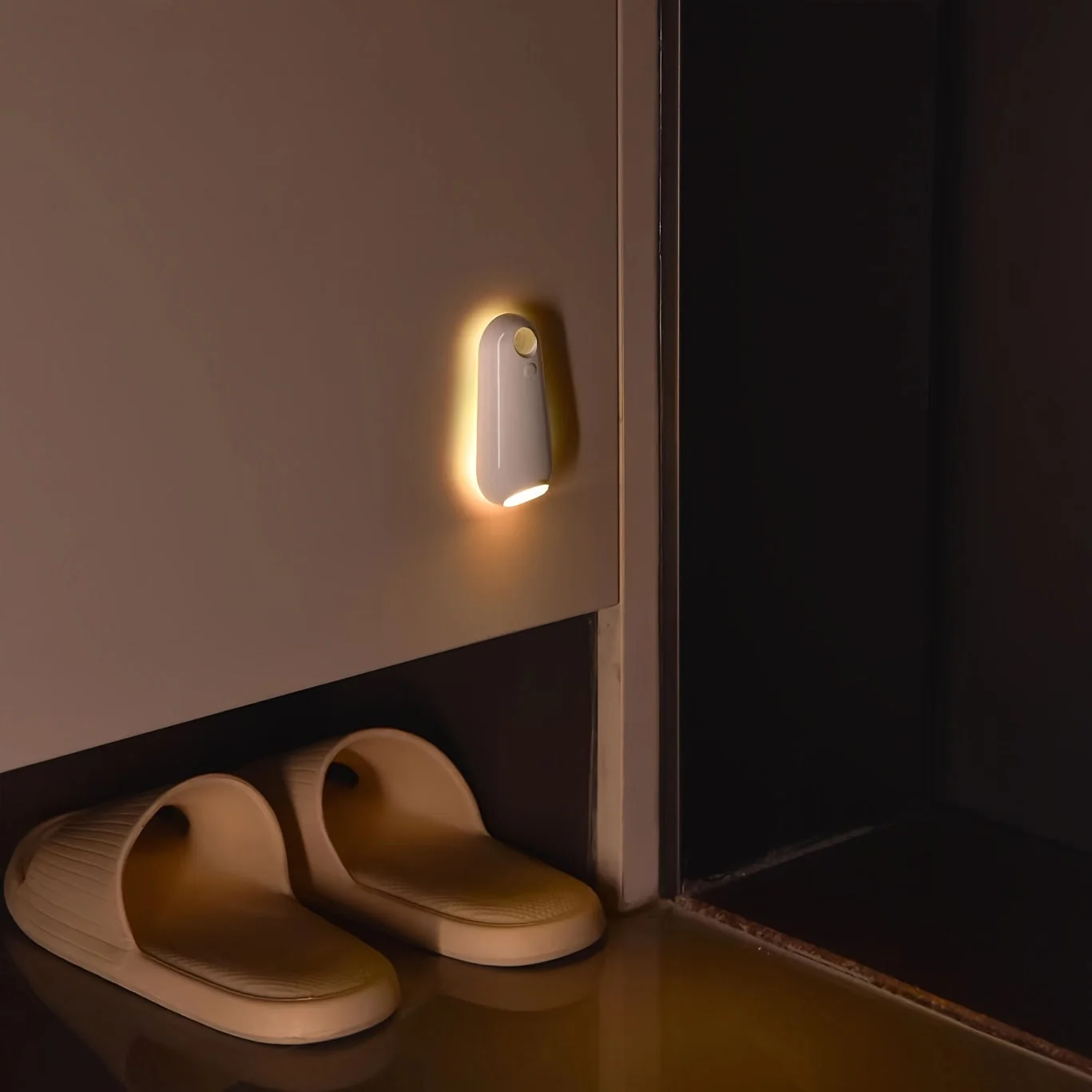 Small wall light fixture on a wall next to a pair of slippers.