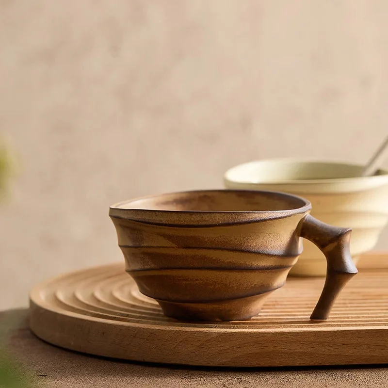 Wooden cup with handle on a wooden surface