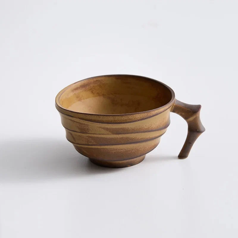 Brown ceramic cup with handle on a white background