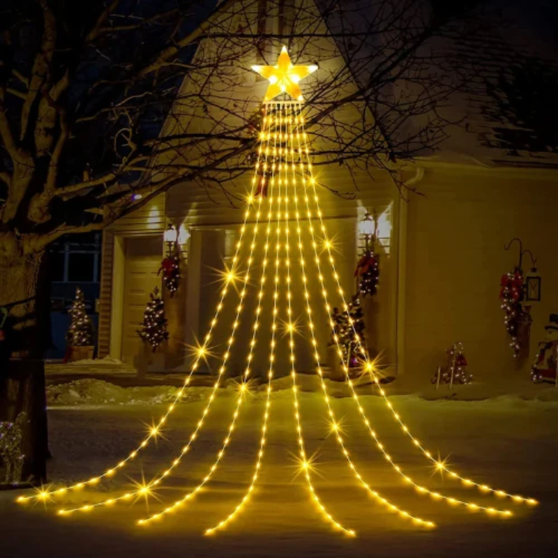 A large Christmas tree string light display shaped like a tree, glowing with warm yellow lights against a dark house exterior at night.