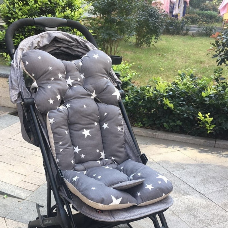 Gray stroller seat with star pattern on a stroller outdoors.