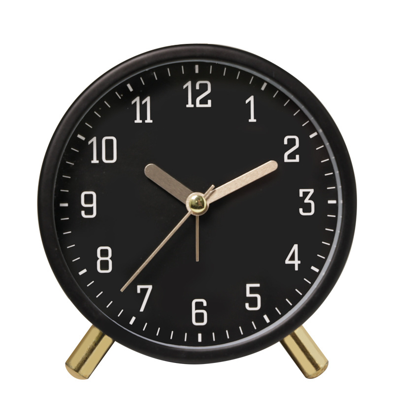 Black alarm clock with gold hands on a white background