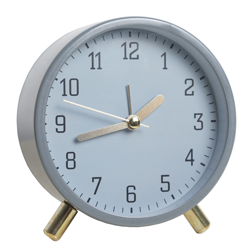 Round alarm clock with a light blue face and gold accents on a white background