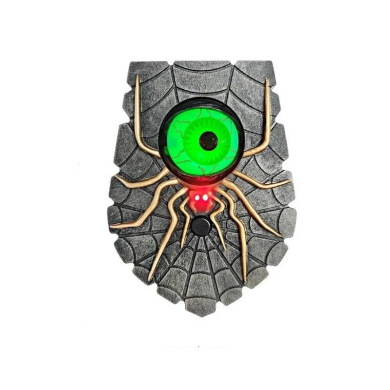 Spider-shaped object with green eye and red button on a white background