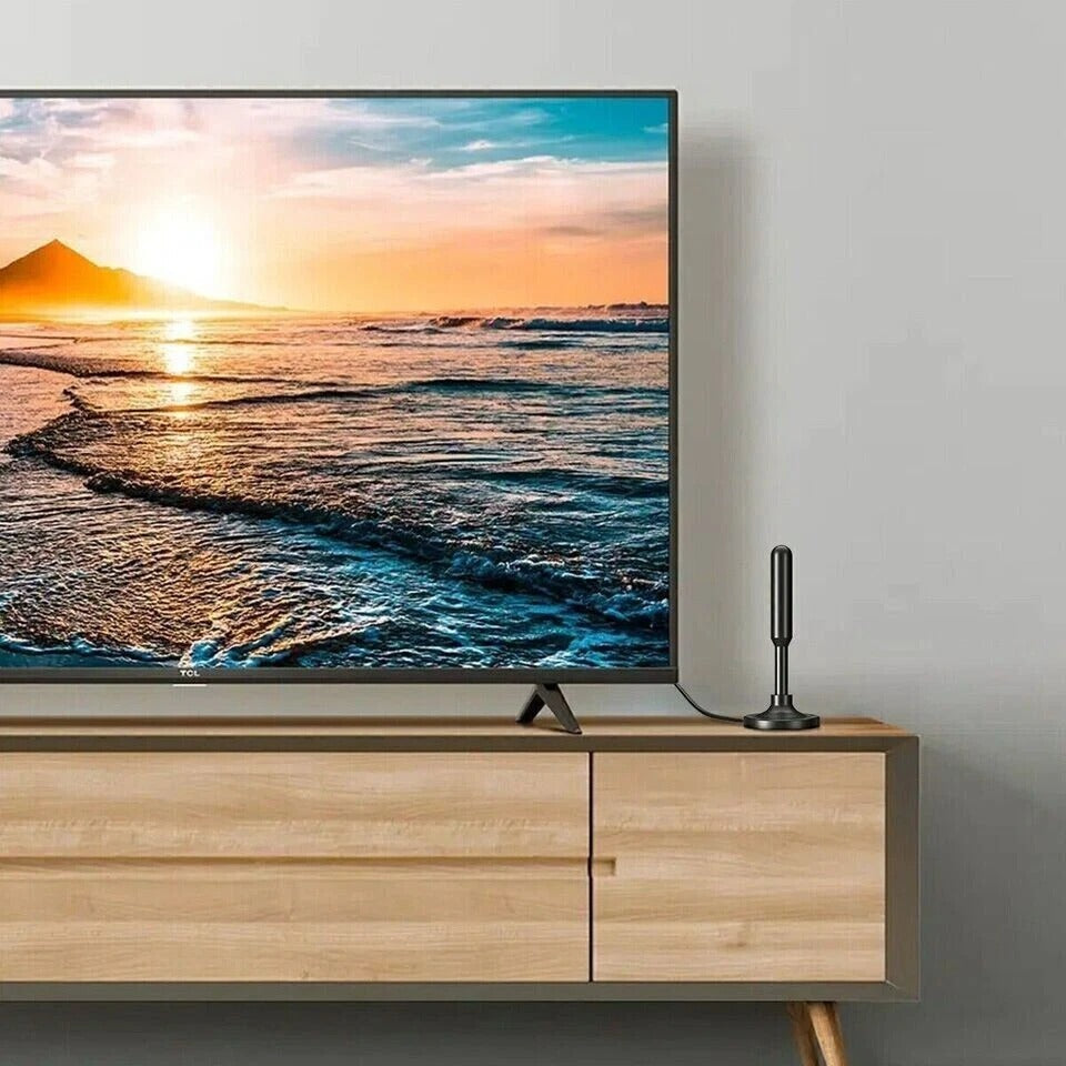Smart TV displaying a sunset over water on a wooden stand with a remote control.