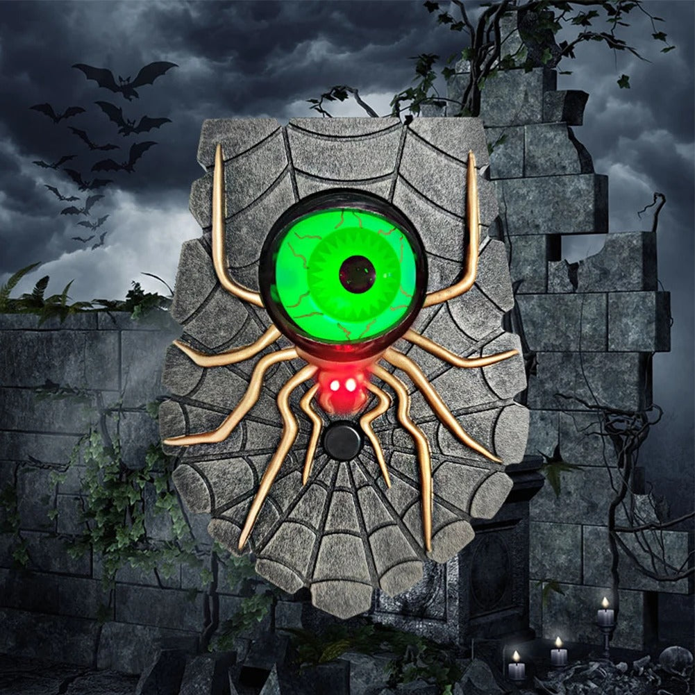A spooky Halloween wall decoration shaped like a giant spider on a stone wall, featuring a glowing green eye and red blinking mouth, set against a dark stormy background with bats and candles.
