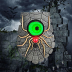 A spooky Halloween wall decoration shaped like a giant spider on a stone wall, featuring a glowing green eye and red blinking mouth, set against a dark stormy background with bats and candles.