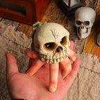 Small decorative skull held in a hand with a rustic background