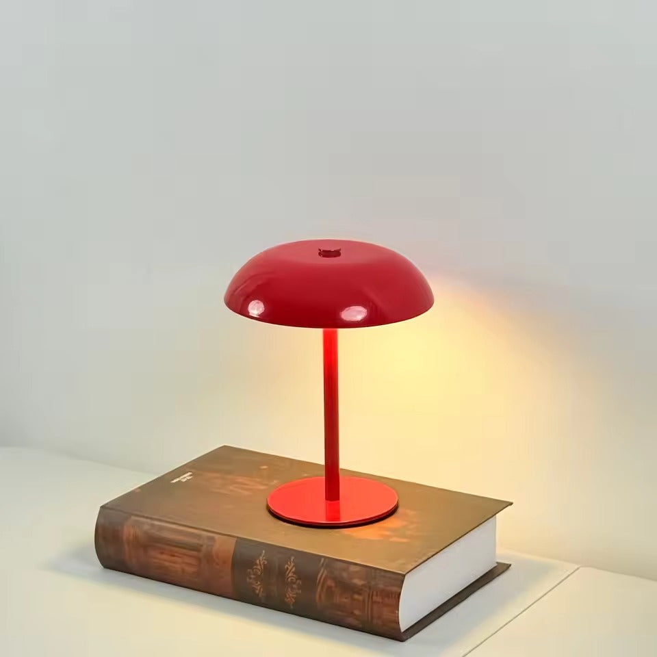 Red table lamp on a book with a soft glow on a light gray background