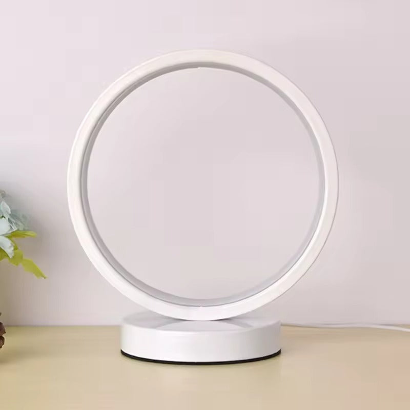Round white lamp on a beige surface with a light purple background