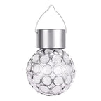 A clear glass solar-powered hanging ornament with a textured circular bubble pattern, a brushed silver metal cap, and a thin silver wire loop at the top, shown against a plain white background.
