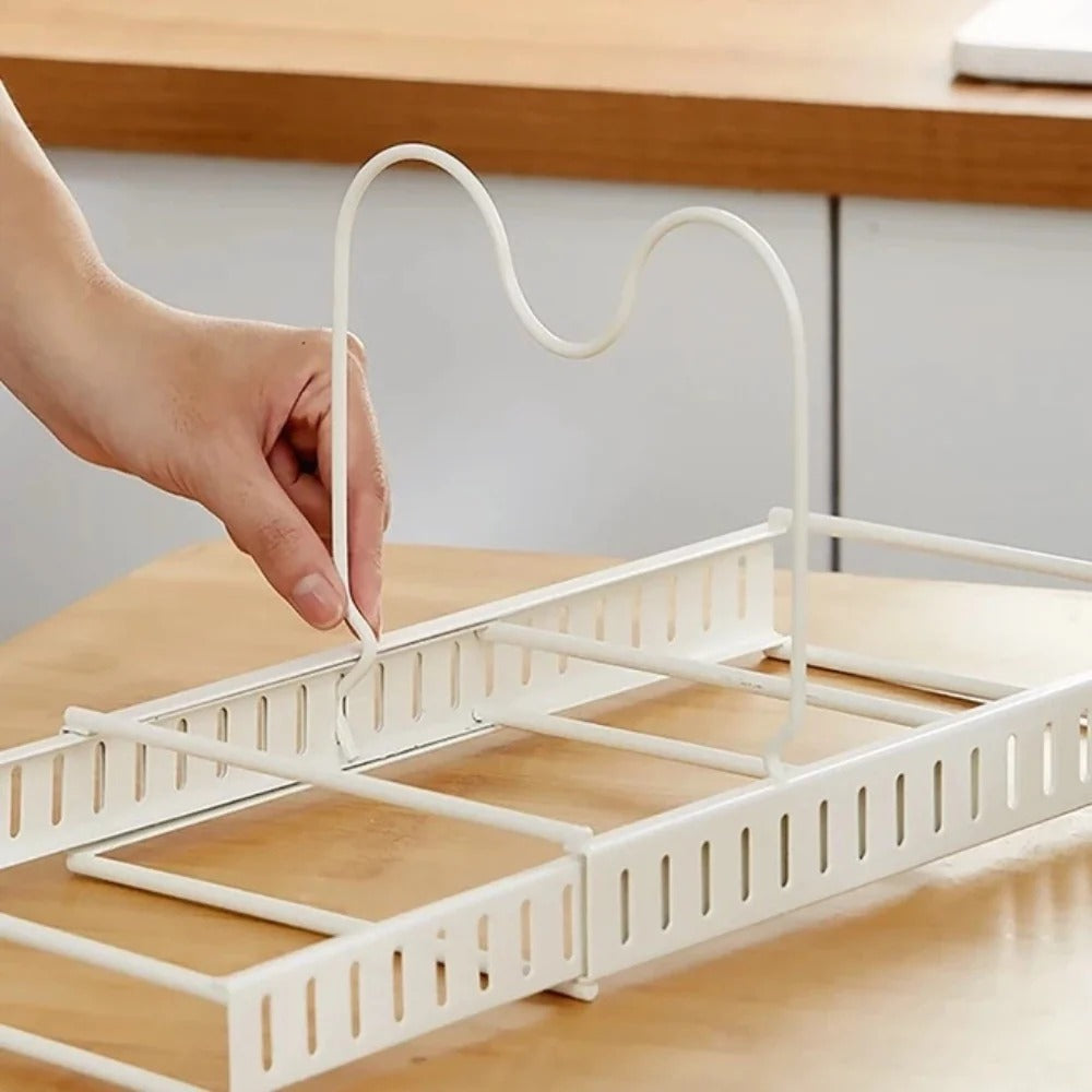 White dish drying rack being adjusted on a wooden surface