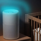 Air purifier emitting a blue light in a room with a crib.