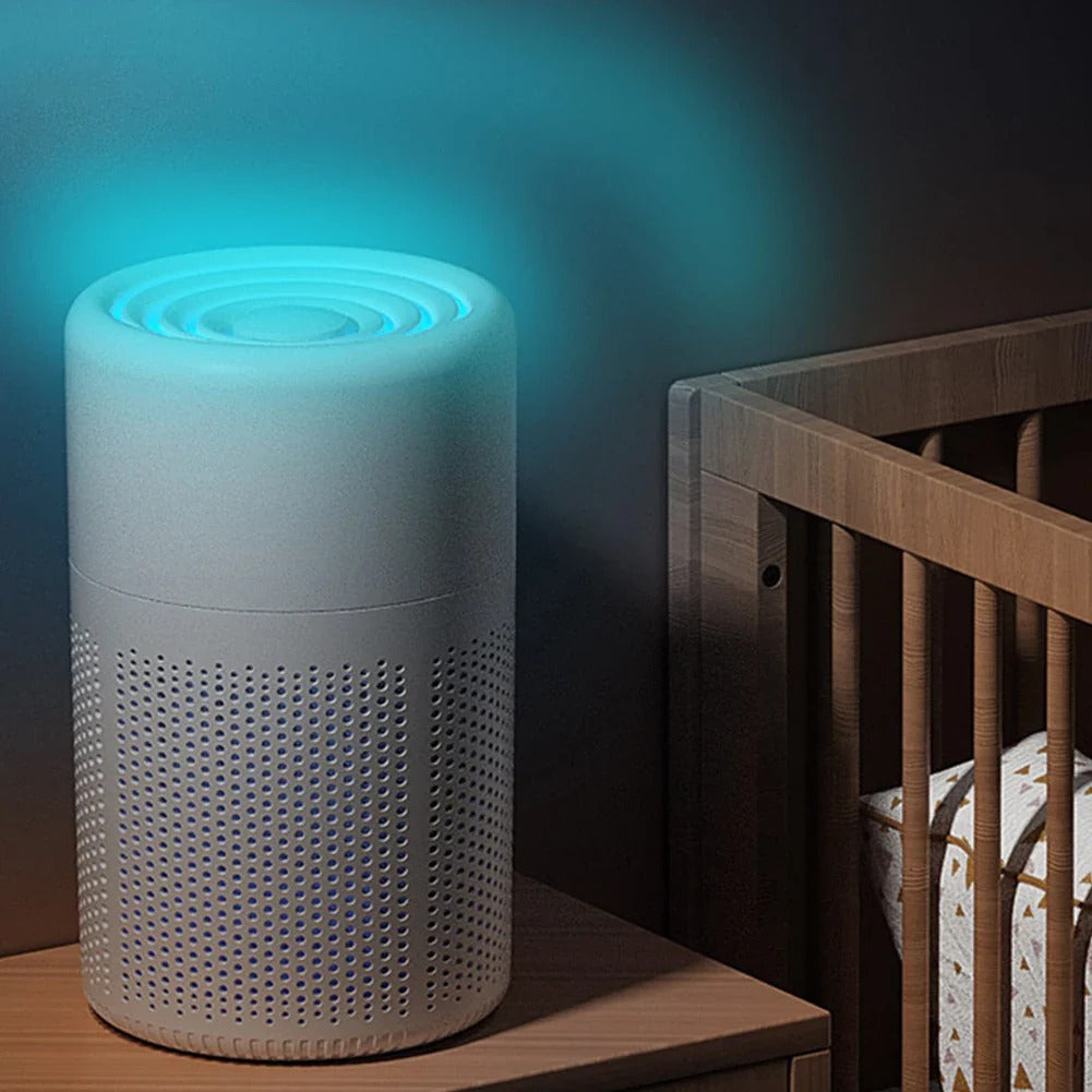 Air purifier emitting a blue light in a room with a crib.