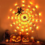 A large Halloween spiderweb decoration made of black string with many warm yellow string lights, shown hanging on a wall above carved pumpkins and candles.