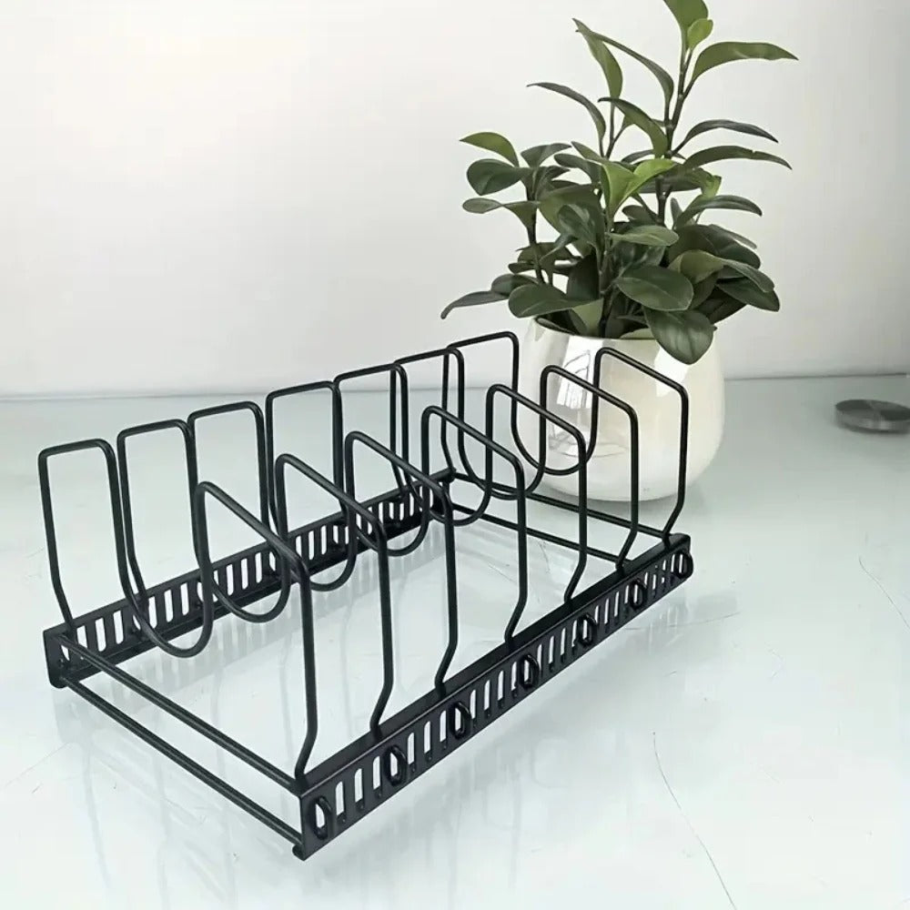 Black dish rack on a white surface with a plant in the background