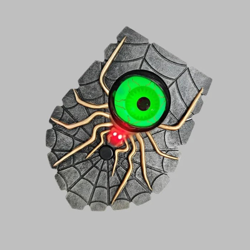 Toy car tire with spider design and glowing eyes on a gray background