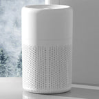 White textured cylindrical container on a light gray surface with a blurred snowy outdoor scene in the background.