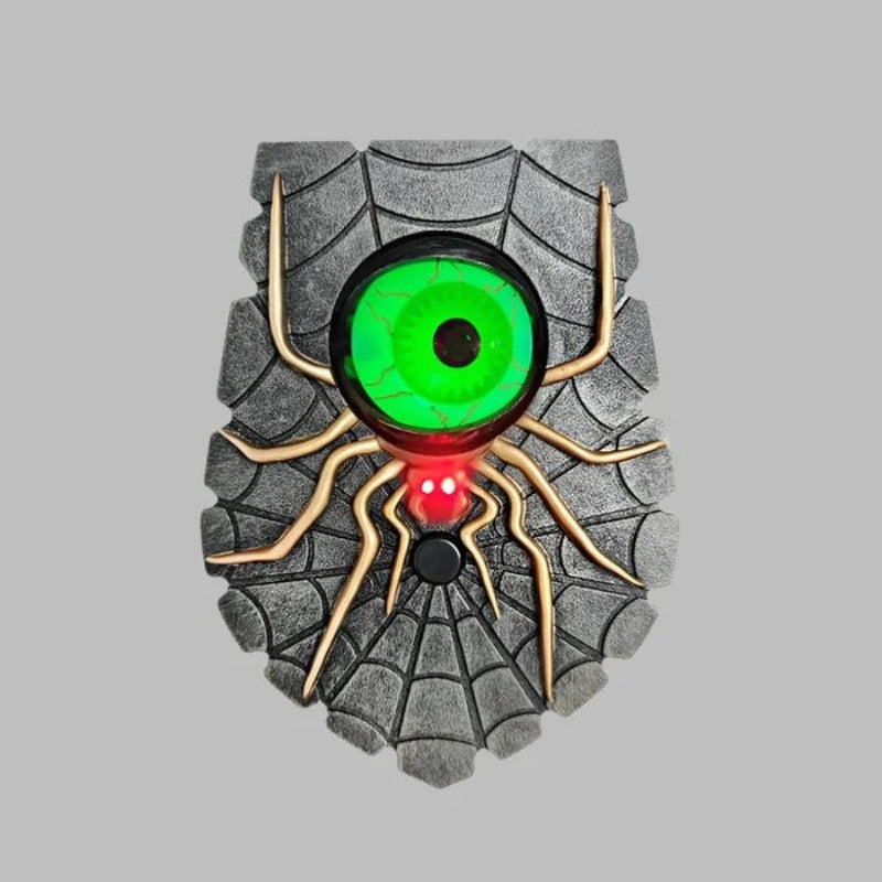 Spider-shaped object with a green eye and red body on a gray background