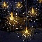 Decorative string lights resembling fireworks in a snowy outdoor setting.