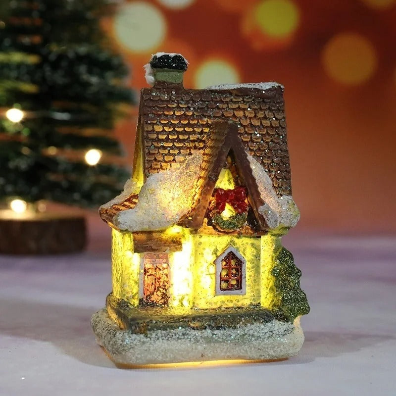 Decorative miniature house with lights on a blurred Christmas tree background