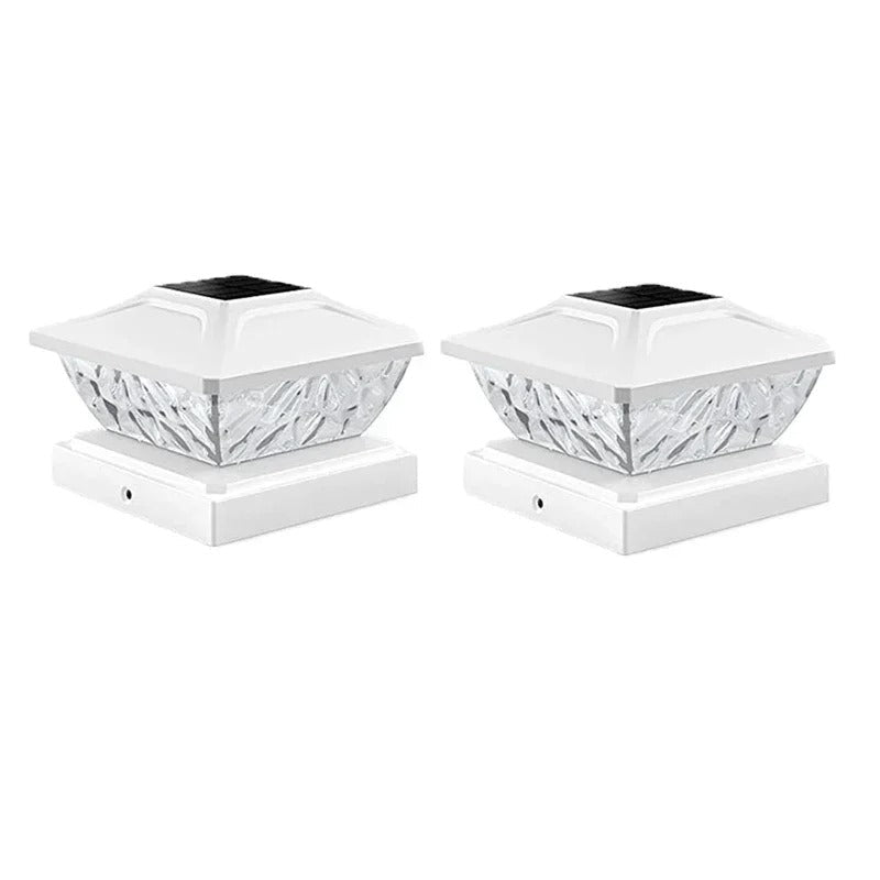 Two white solar fence post caps with decorative design on a white background.