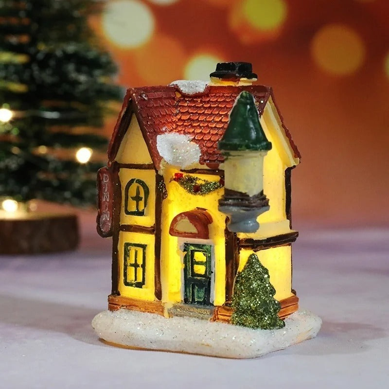 Decorative miniature house with a lit interior, surrounded by a festive background.