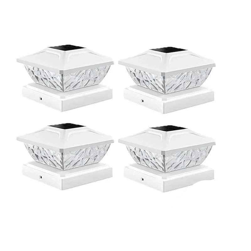 Four white solar post cap lights with decorative design on a white background.