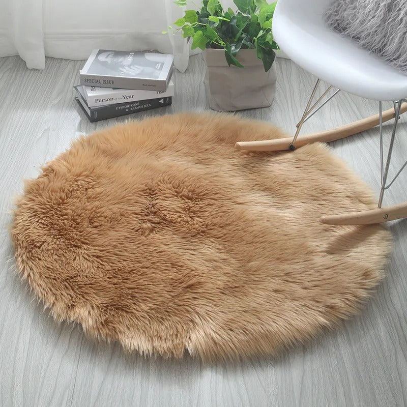 Round brown fur rug on a light wooden floor with a plant and books in the background.