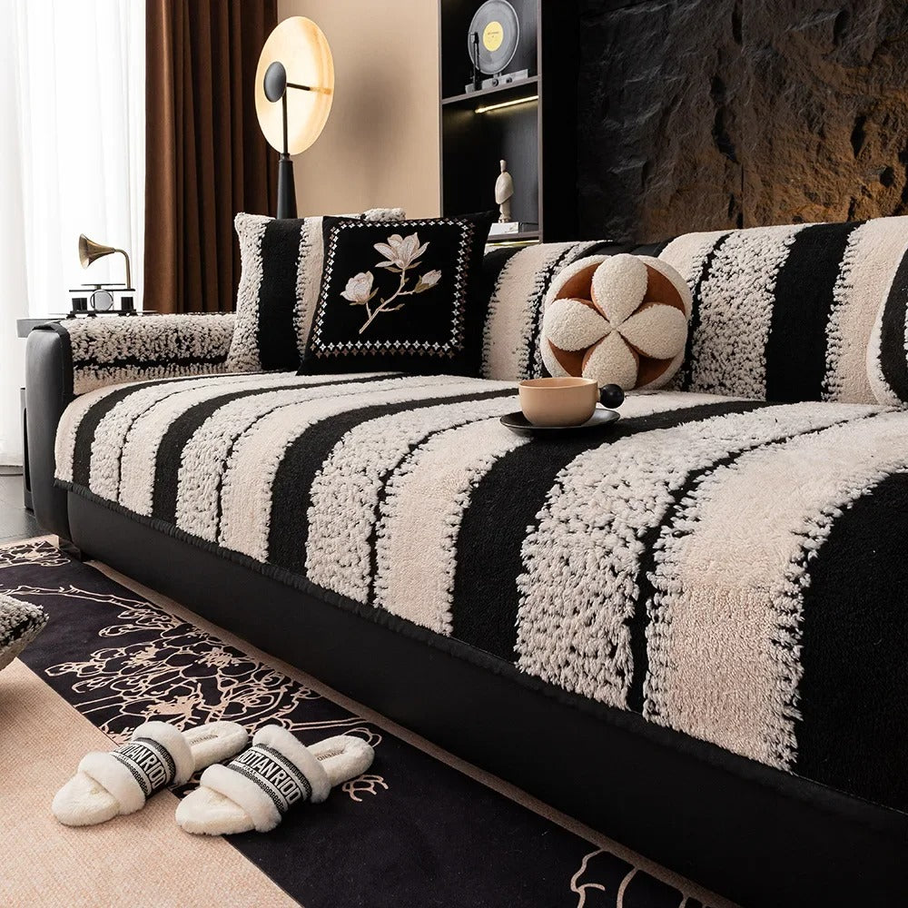 Black and white striped sofa with decorative pillows in a living room setting.
