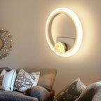 Decorative wall mirror with a light fixture in a living room setting.