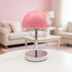 Pink table lamp on a white surface with a blurred living room background