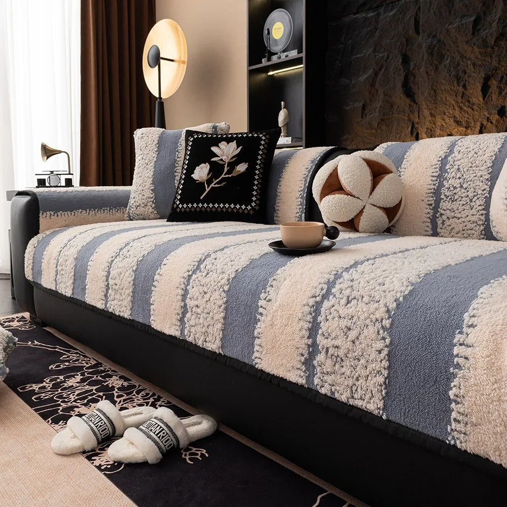 Striped sofa with decorative pillows and a cup in a living room setting