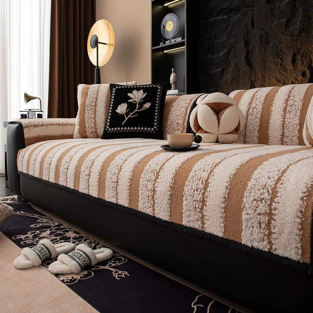 Striped sofa with decorative pillows and a coffee table in a living room setting.