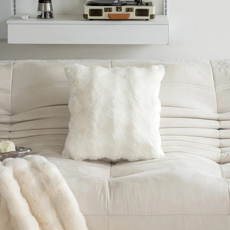 White pillow on a white sofa with a white background