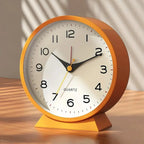 Orange clock on a wooden surface with a neutral background