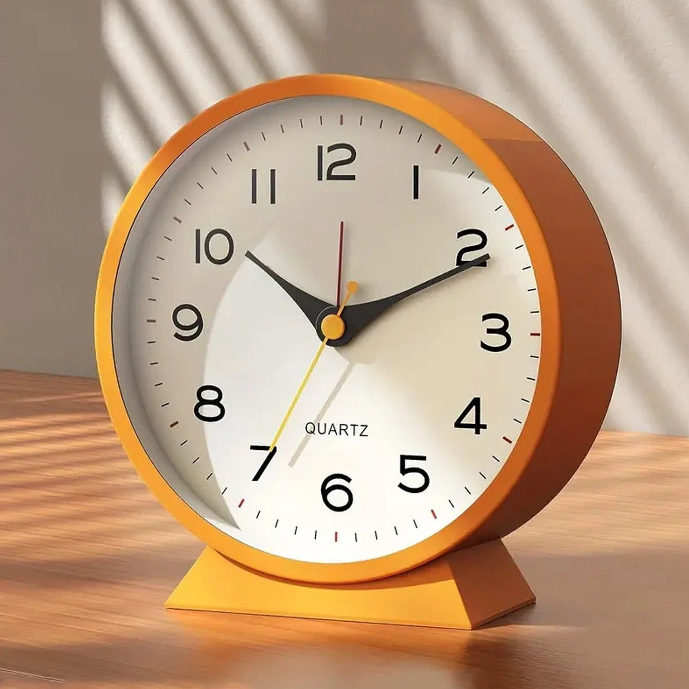 Orange clock on a wooden surface with a neutral background