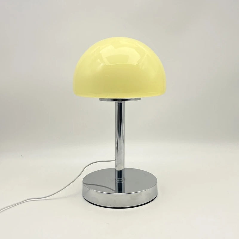 Yellow table lamp with a chrome base on a white background