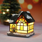 Decorative lit house with a snowy roof, surrounded by a festive background.