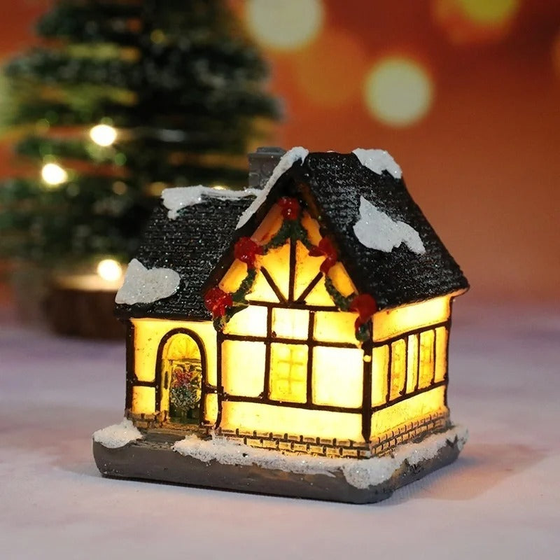 Decorative lit house with a snowy roof, surrounded by a festive background.
