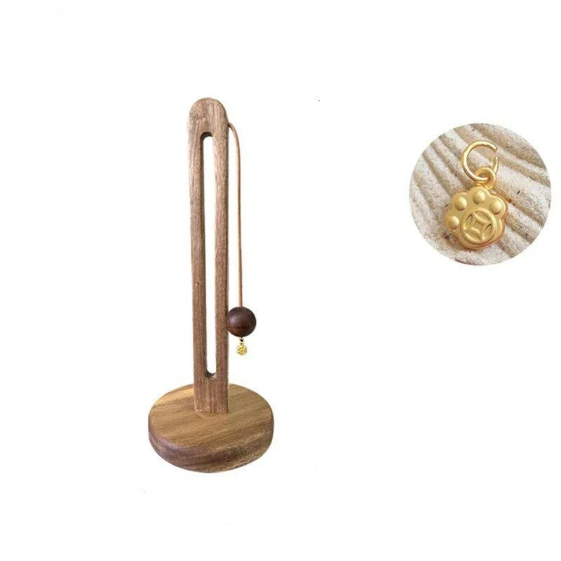 Wooden earring stand with gold earring and paw charm, showing dimensions on a white background.