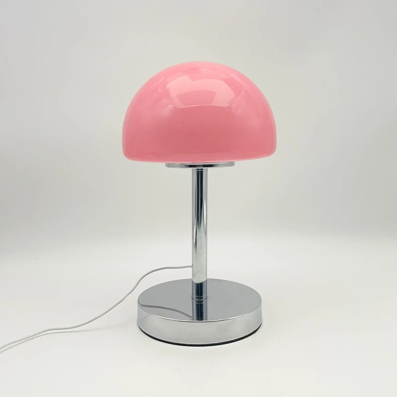 Pink table lamp with a chrome base on a white background