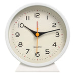White clock with a beige face on a white background