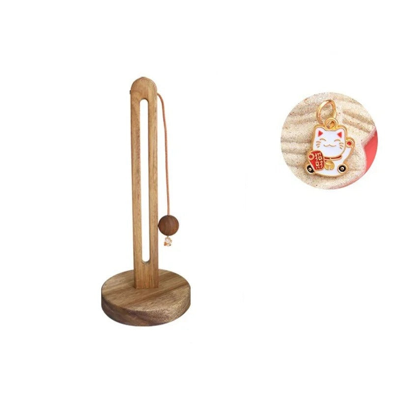 Wooden stand with a small round object and a charm with a cat design, showing measurements on a white background.