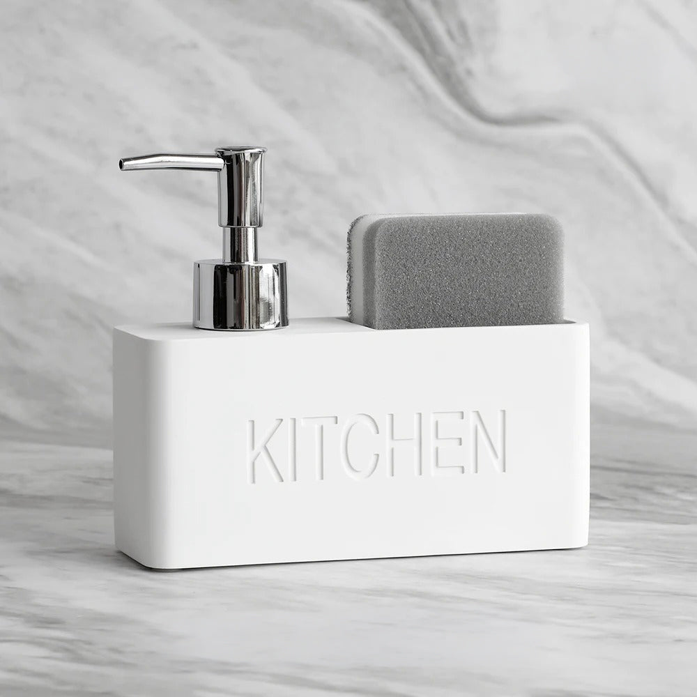 White kitchen sink caddy with soap dispenser and sponge on a marble countertop