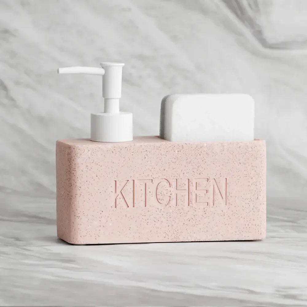 Pink kitchen soap dispenser with white pump on a marble surface